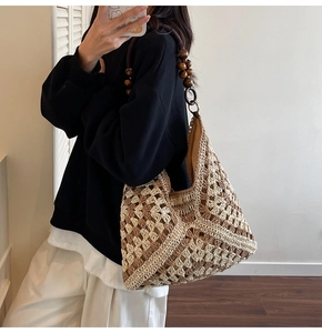 Detail of woven tote bag featuring khaki color block patterns and wooden bead straps