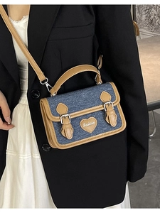 Blue denim mini crossbody bag with brown leather trim and heart fashion detail
