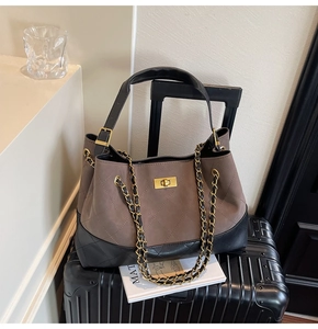 Detail of quilted tote bag featuring two-tone design and gold metal twist-lock buckle