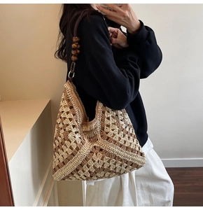 Detail of woven straw tote with hollow rhombus patterns and vintage wooden bead accents
