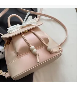 Detail of pink mini backpack featuring white lace bow and soft premium texture fabric