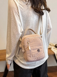 Light pink crinkled nylon multi-zipper crossbody bag with adjustable strap for women