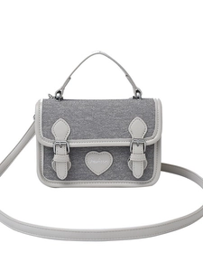 Gray denim crossbody bag with cream trim and heart patch on a white background