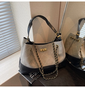 Detail view of quilted leather tote with gold twist lock and chain strap for women