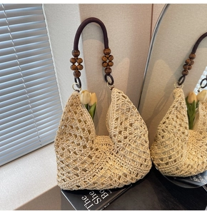Detail of woven straw tote bag with diamond pattern, wooden bead trim and fabric handles