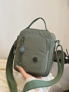 Army green nylon crossbody bag with multi-zipper pockets and wide shoulder strap