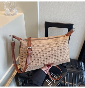 Dettaglio della borsa in rete beige con tracolla in pelle marrone e fibbia argento