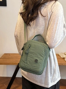 Morandi green nylon multi-zipper crossbody bag shown on a model for size and style
