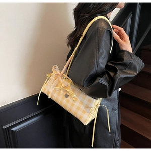 Detail of yellow plaid shoulder bag featuring white lace trim and bow knot decoration