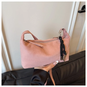 Detail of pink faux suede shoulder bag with heart charm and matte texture finish