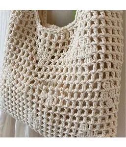 Detailed macro view of beige hollow-out crochet weave texture on handmade beach bag
