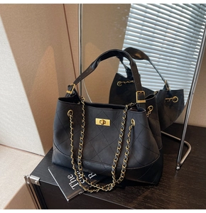 Detail of black quilted leather tote with gold chain strap and metallic turn-lock closure