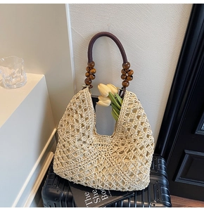 Close-up of a woven tote bag with wooden bead handle on a suitcase with tulips