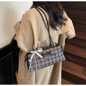 Fashionable checkered shoulder bag with black bow and lace ribbons shown from the side