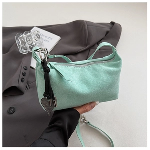 Dettaglio borsa a tracolla scamosciata verde menta con ciondolo a cuore e fibbie metalliche