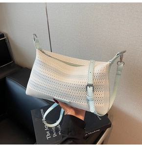 Dettaglio della borsa intrecciata bianca con tracolla in pelle azzurra e fibbia argento