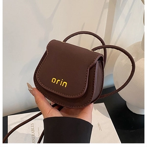 Detailed close-up of dark brown mini saddle bag with leather texture and orin logo