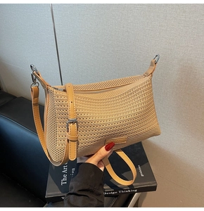 Dettaglio della trama della borsa intrecciata con tracolla in pelle e fibbia argentata