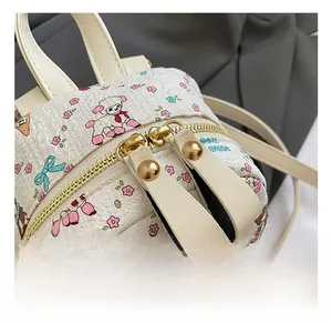 Gros plan du zip doré et du cuir texturé du sac à dos avec motif dessin animé