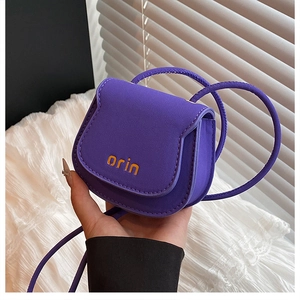 Detailed close-up of a purple mini saddle bag with drawstring strap and brand logo