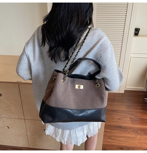 Close-up of quilted tote bag with chain strap and gold twist lock in dark coffee brown