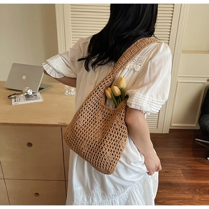 Gros plan d'un sac cabas tissé ajouré avec un bouquet de tulipes pour style de plage