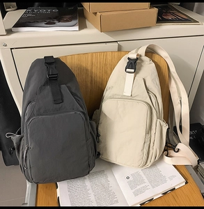 Detailed view of durable nylon multi-pocket crossbody bags in dark grey and beige colors
