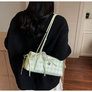 Close-up of light green plaid shoulder bag featuring lace trim and bow knot detail