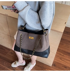 Detail of a brown suede quilted tote bag with gold twist lock and chain strap