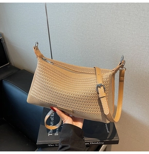 Dettaglio borsa tessuta color kaki chiaro con etichetta logo e tracolla in pelle regolabile
