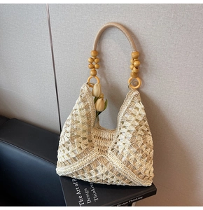 Close-up of woven tote bag with wood bead handles and detailed hollow weave texture