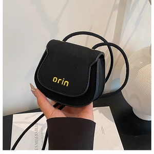Close-up of black matte leather mini saddle bag with yellow orin brand embroidery