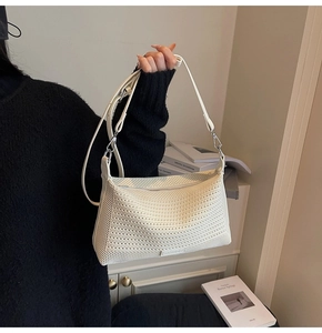 Vista dettagliata della borsa hobo bianca intrecciata con tracolla e cerniera in metallo