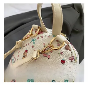 Détails des crochets métalliques dorés sur le sac à dos blanc à motif cartoon