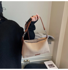 Dettaglio della borsa a spalla in paglia intrecciata con tracolla in pelle marrone