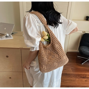 Détail du sac cabas en paille évidé tissé à la main avec bandoulière tressée d'été