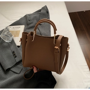 Brown lychee leather bucket bag with gold metal handle and adjustable long shoulder strap