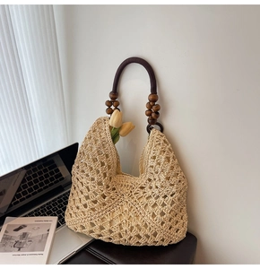 Detail of hollow woven beige tote with vintage wooden bead handle and rustic texture
