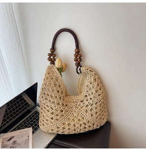 Detail of woven tote bag featuring hollow texture and unique dark wood beaded handle