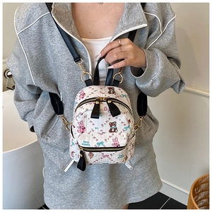 Détail d'un mini sac à dos blanc avec imprimés de lapin dessin animé et fermoirs dorés