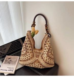 Detail of woven straw tote bag with beaded wooden handle and hollow diamond texture
