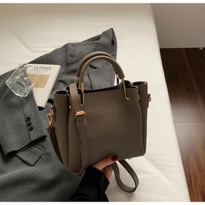 Top view of brown lychee grain leather bucket bag with gold hardware and shoulder strap