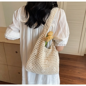 Close-up of cream woven crochet tote bag with artisan texture and floral tulip accent