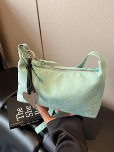 Chic mint green suede underarm bag with decorative knot and heart metal pendant