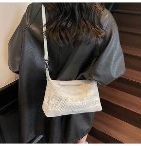 Vista posteriore della modella con borsa intrecciata bianca e tracolla verde menta