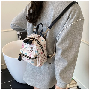 Détail du mini sac à dos blanc avec imprimés cartoon mignons et boucles dorées chic