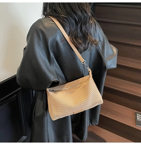 Dettaglio della borsa a spalla in rete intrecciata beige con cinturino in pelle e zip