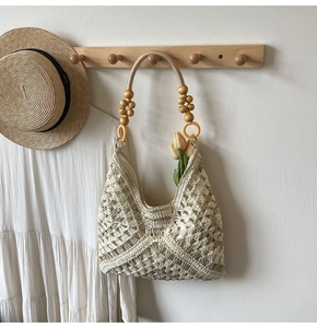 Detail view of hand-woven crochet tote bag featuring wooden beads and tulip decorations