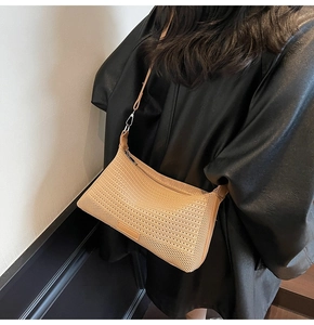 Dettaglio della trama intrecciata di una borsa a spalla beige con cinturino e cerniera