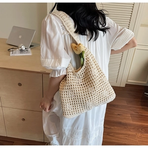 Detailed texture of cream crochet net tote bag with hollow woven cotton rope design